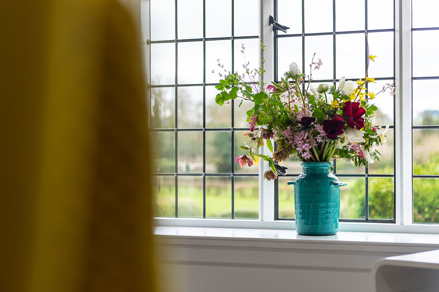 A vase of flowers on a window sill
